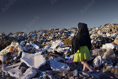 Sad child on garbage dump