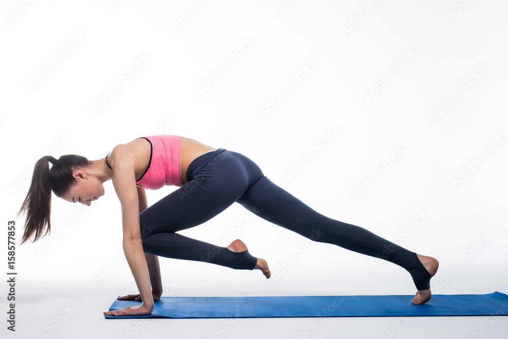 Sporty young woman doing yoga practice isolated on white background