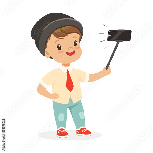 Cute little boy in fashionable clothes taking selfie with a selfie stick, colorful cartoon character vector Illustration