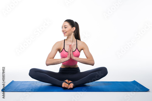 Sporty young woman doing yoga practice isolated on white background