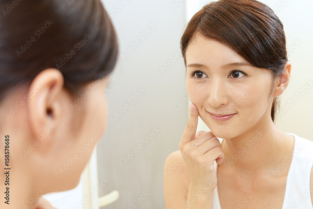 鏡を見て微笑む女性 鏡を見て微笑む女性