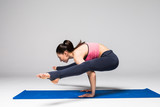 Young attractive woman practicing yoga, standing in different yoga exercise, wearing sportswear isolated on grey background. Series of Yoga position concept