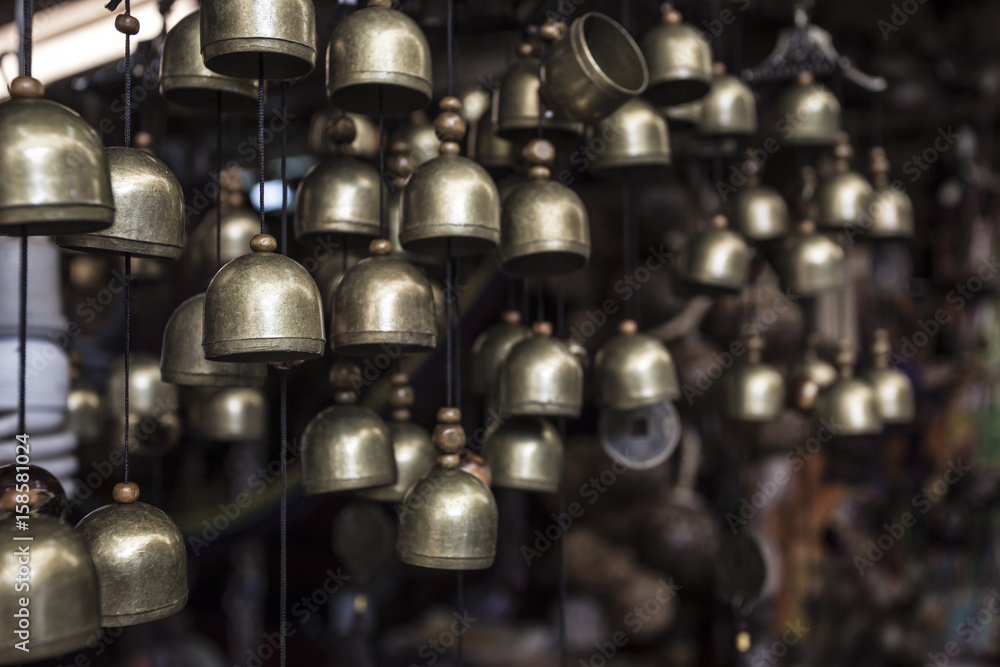 a lot of small brass brass bells hanging in the small souvenir shop in the asia - beautiful symbol of peace, harmony, balance, poise, goodness, compassion and meaningfulness a lot of small brass brass bells hanging in the small souvenir shop in the asia - beautiful symbol of peace, harmony, balance, poise, goodness, compassion and meaningfulness