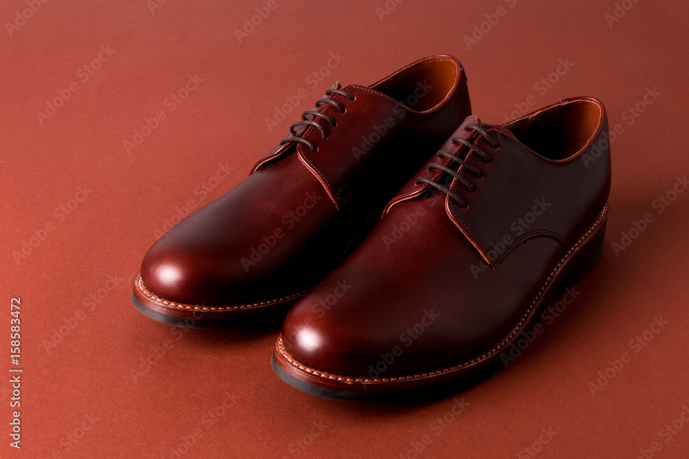 Brown oxford shoes on red background. Close up. Brown oxford shoes on red background. Close up.