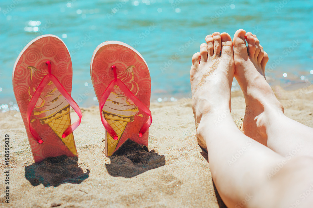 feet and flip flops on beach Photos Adobe Stock