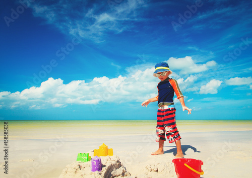 little boy play with sand on beach