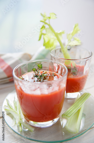 Two glasses of fresh tomato juice with thyme and celery.
