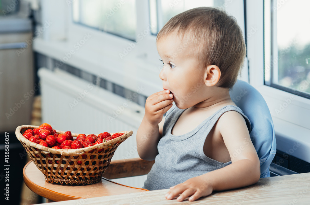 the child in the kitchen eating strawberries the child in the kitchen eating strawberries