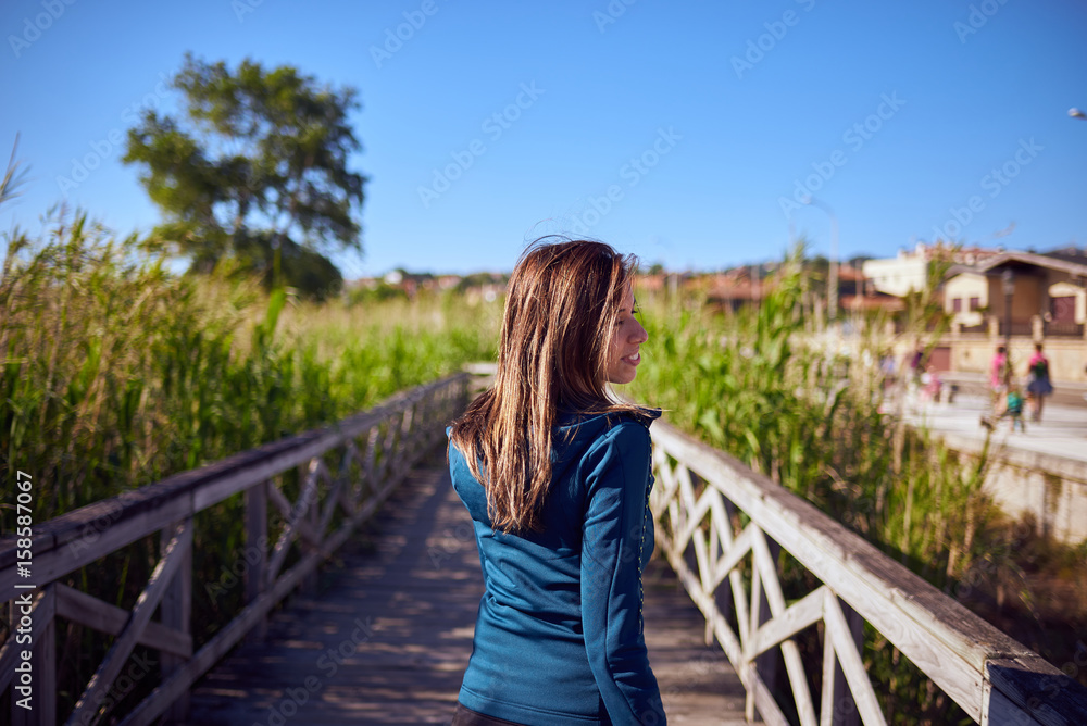 Mujer joven sobre una pasarela de madera
