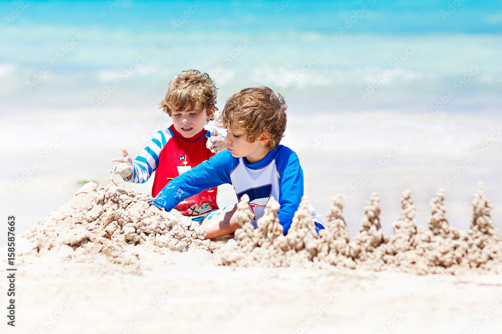 Two kid boys building sand castle on tropical beach of Bora Bora Two kid boys building sand castle on tropical beach of Bora Bora
