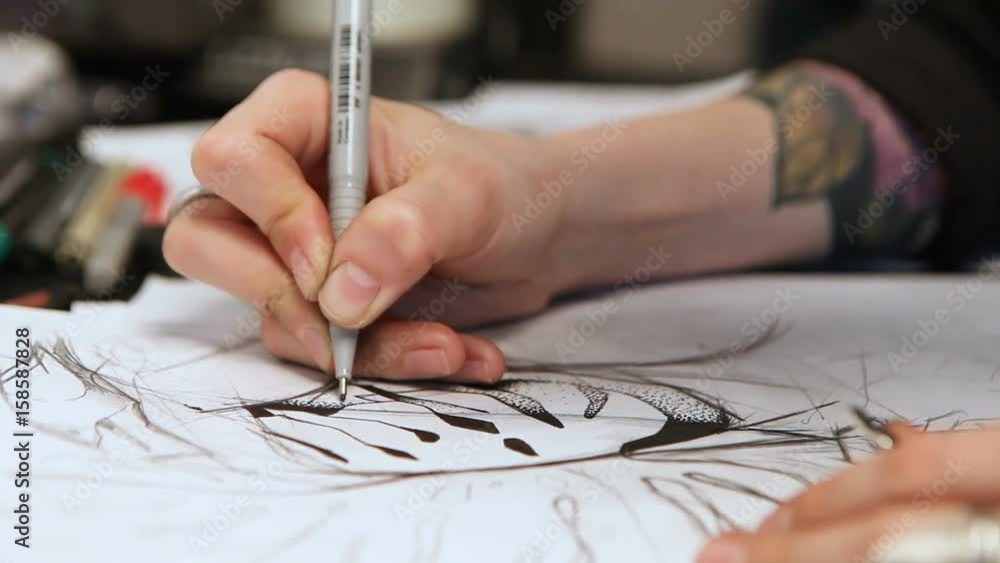 Girl tattoo artist draws a sketch. Close-up of hands Girl tattoo artist draws a sketch. Close-up of hands
