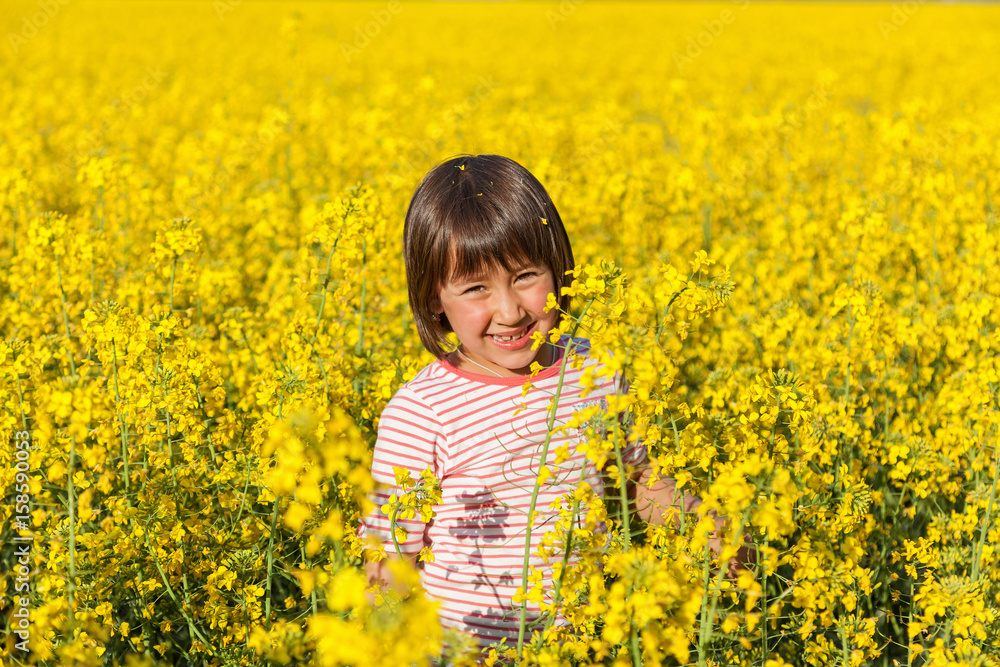 children in the field with the flowering yellow flowers of rape children in the field with the flowering yellow flowers of rape