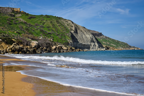 Waves washing the sandy beach of Ramla bay close-up - Gozo, Malta