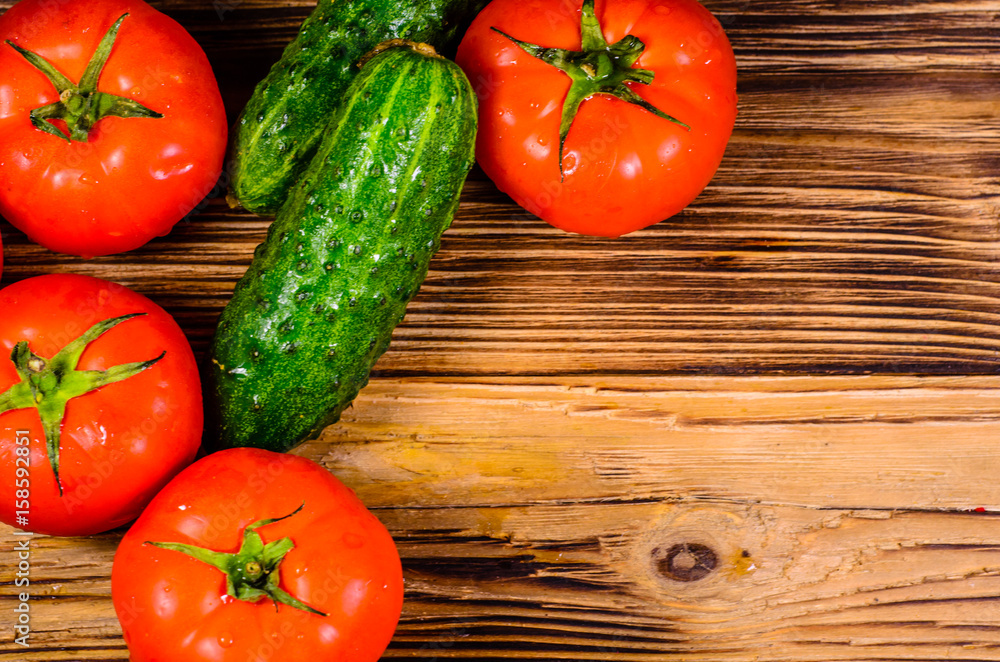 Ripe tomatoes and cucumbers on wooden table. Top view Ripe tomatoes and cucumbers on wooden table. Top view