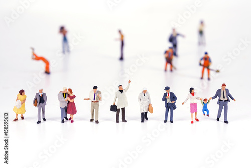 Line of diverse tiny miniature model people photo