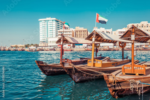 Piers of traditional water taxi boats in Dubai, UAE. Panoramic view on Creek gulf and Deira area. Creative color post processing. United Arab Emirates famous tourist destination