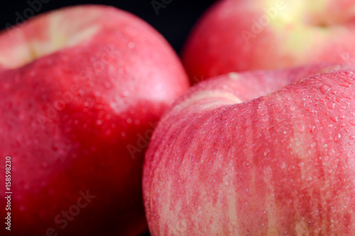 Closeup of red apples on black background, focus on front apple