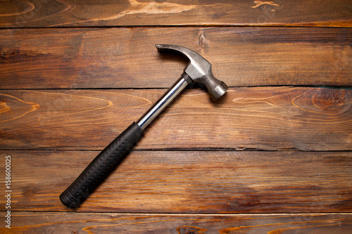 Iron hammer on wooden background. Top view