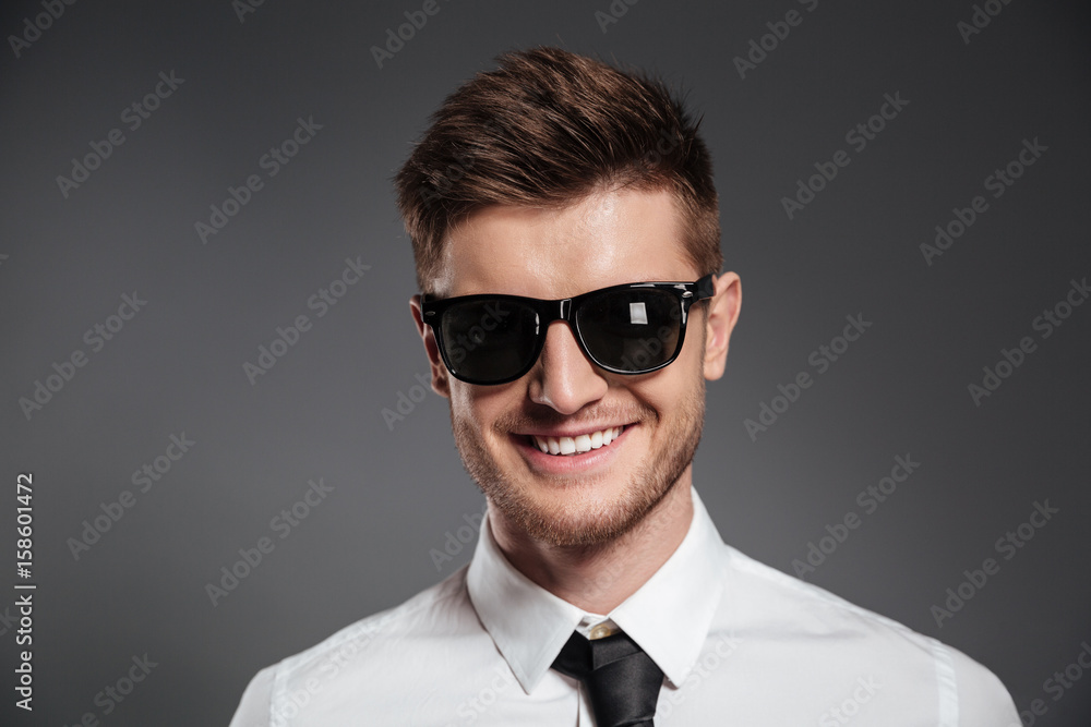 Close up portrait of a smiling stylish man in sunglasses Close up portrait of a smiling stylish man in sunglasses
