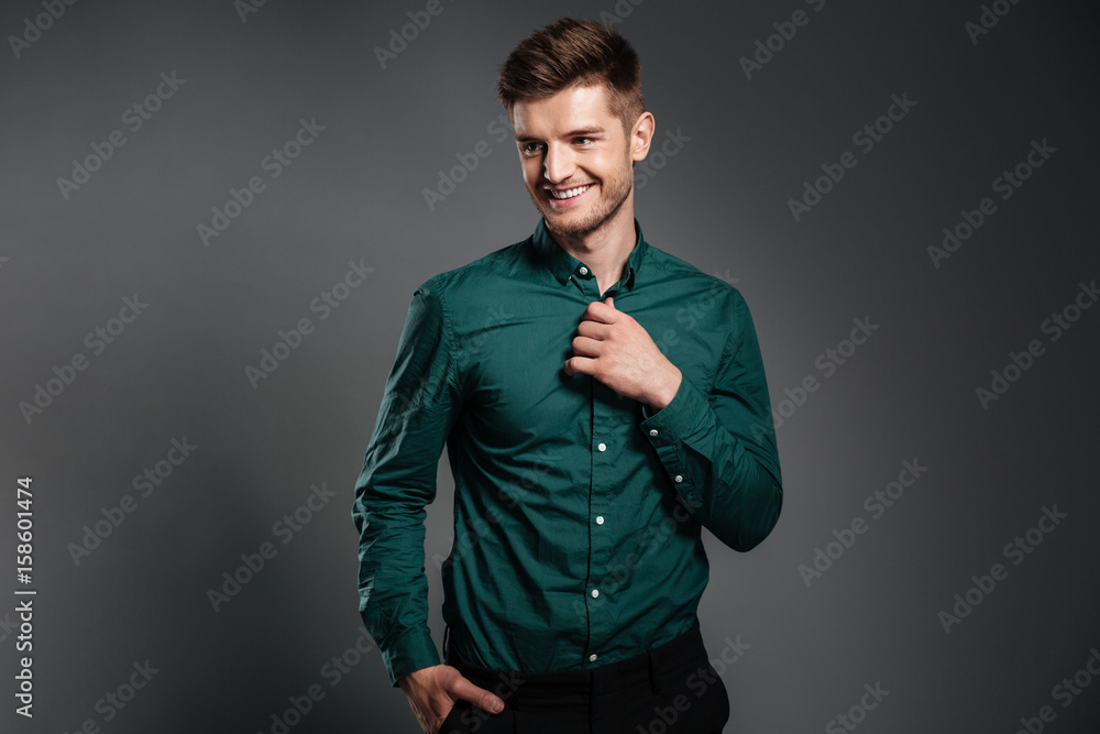 Happy young man posing isolated over grey background Happy young man posing isolated over grey background