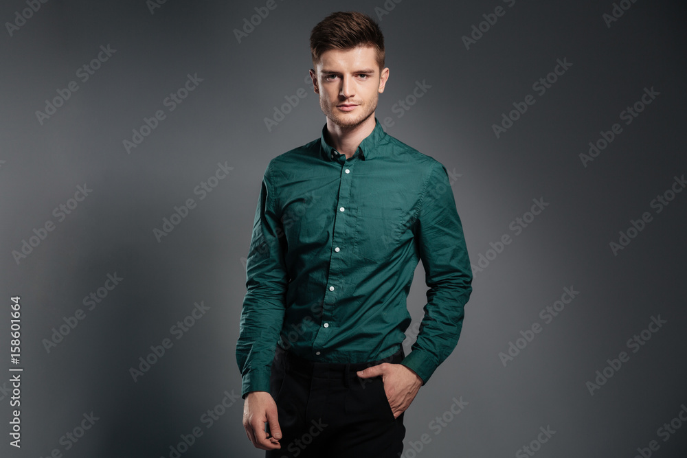 Handsome serious man dressed in shirt posing