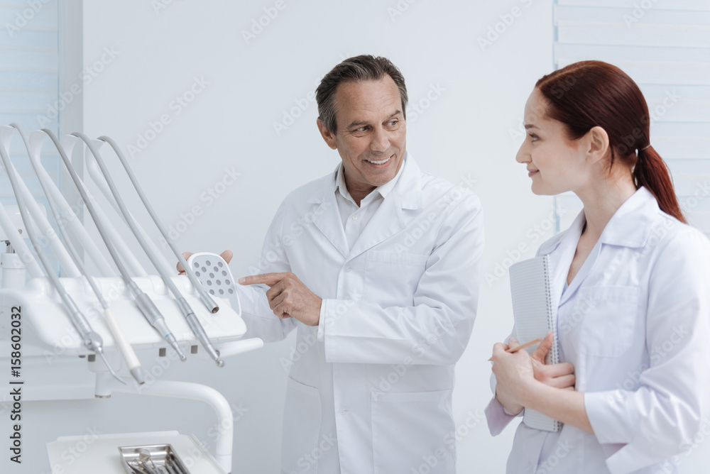 Fototapeta premium Handsome dentist showing big device