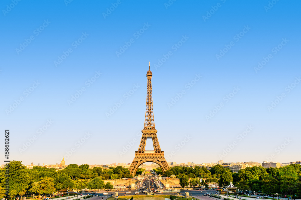 Fototapeta premium The Eiffel tower seen from the Trocadero esplanade in a warm light at sunset.
