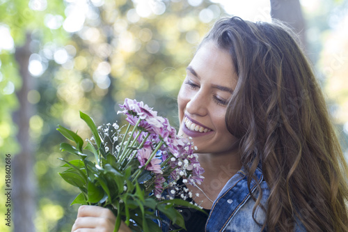 Portrait of a beautiful young woman holding flowers in her hand