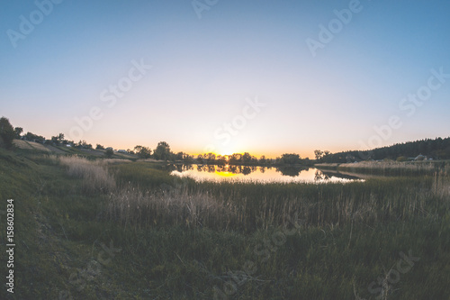 Pond in the evening landscape in the sunset of a summer day.