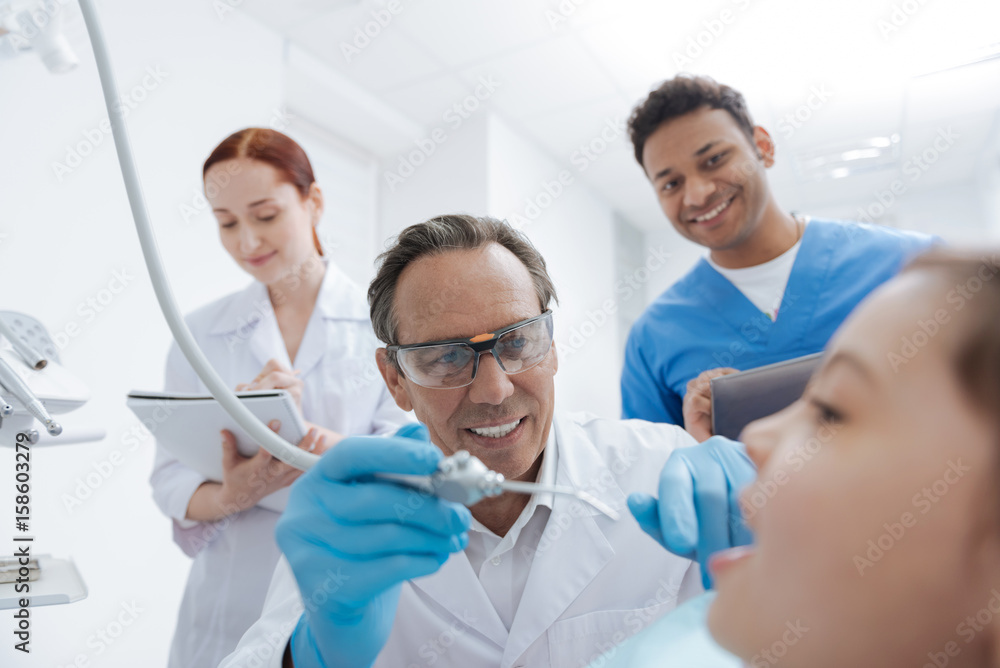 Obraz premium Attentive stomatologist checking teeth of his patient