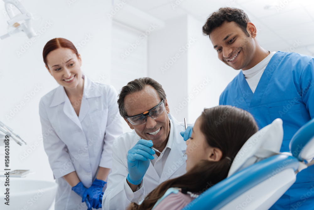 Three stomatologists calming little girl Three stomatologists calming little girl