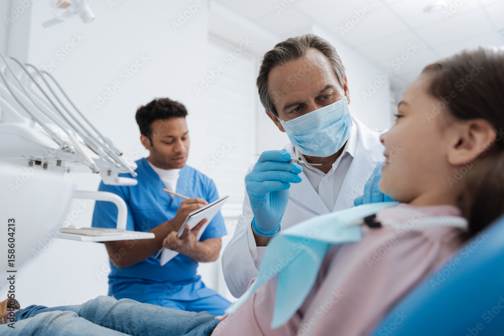 Obraz premium Delighted girl lying on stomatologist chair in semi position
