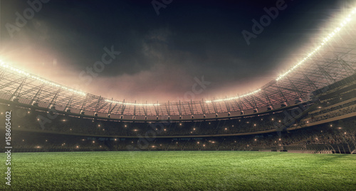 soccer stadium with green grass, illumination lights and dramatic night sky © TandemBranding