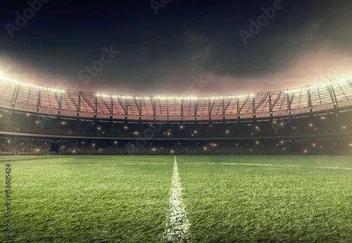 Obraz stadion piłkarski z zieloną trawą i oświetleniem w nocy