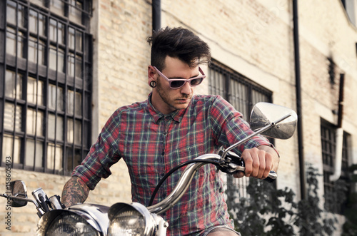 Closeup of handsome young man holding motorcycle bars 