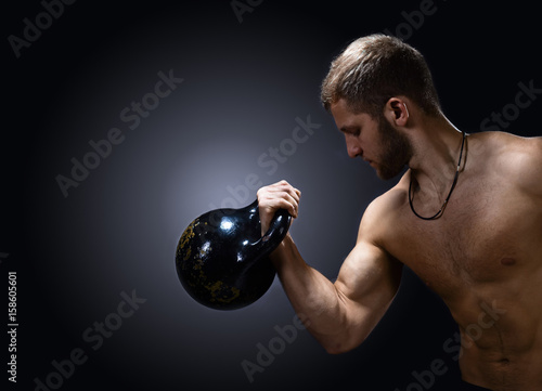 Young bodybuilder on a black background © Igor Normann