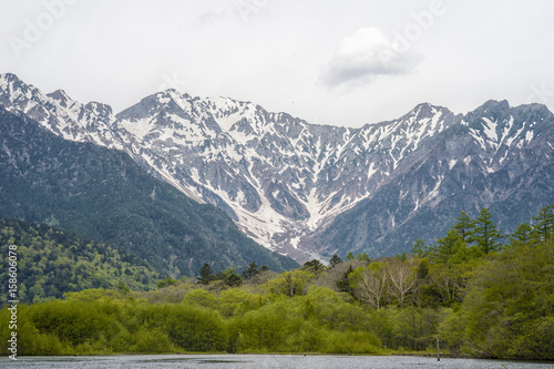 Hotaka mountain range and taisho ike pond in spring at kamikochi national park nagano japan photo