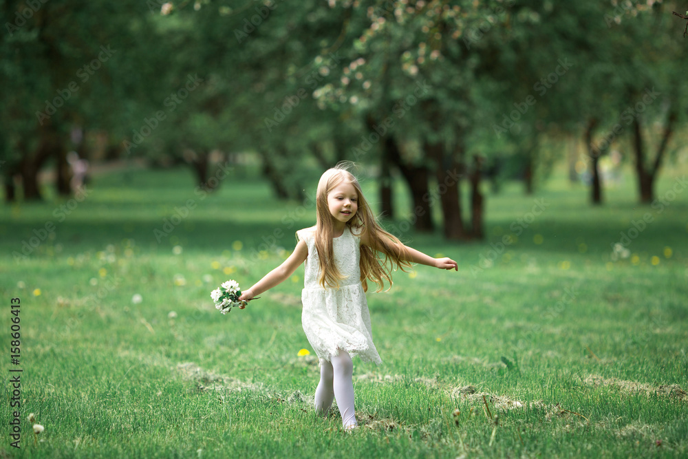 Little girl is walking in an apple garden Little girl is walking in an apple garden