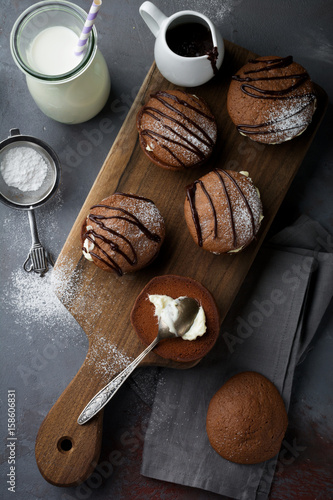 Chocolate cookies of  Woopie  Cookie with mascarpone cream on a gray dark concrete background. Selective focus. Top view. Space for text. photo