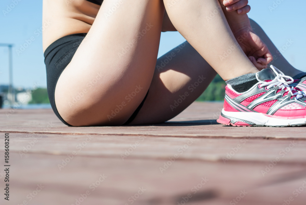 Fitness girl sitting on a wooden floor on the shore of the lake. Slender  figure, sportswear, smooth skin. Stock Photo | Adobe Stock