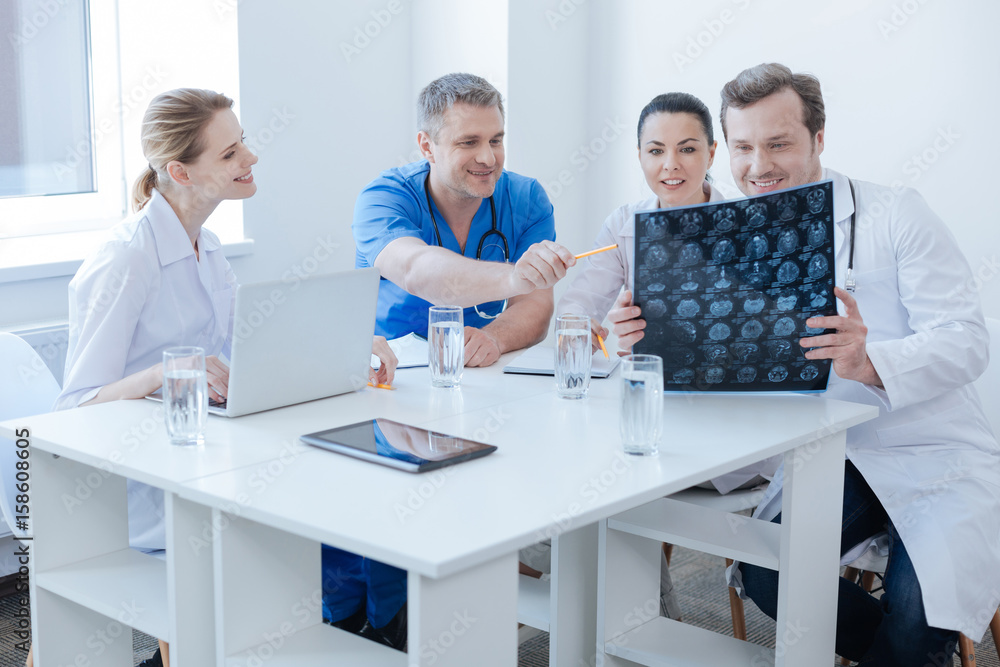 Optimistic radiologists discussing brain x ray image at the laboratory