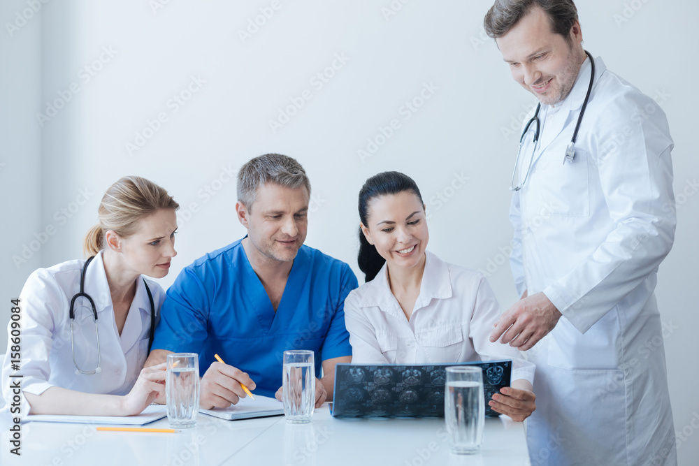 Fototapeta premium Optimistic traumatic surgeons analyzing x ray photo at the clinic