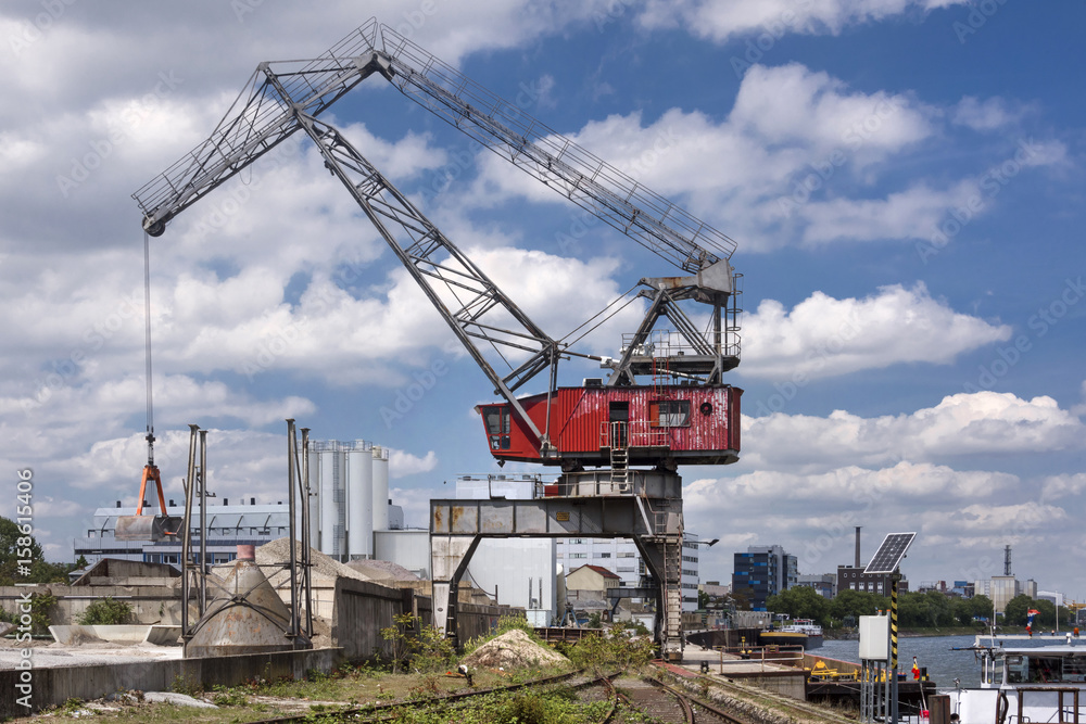 Red old harbor crane on rails at Rhine river