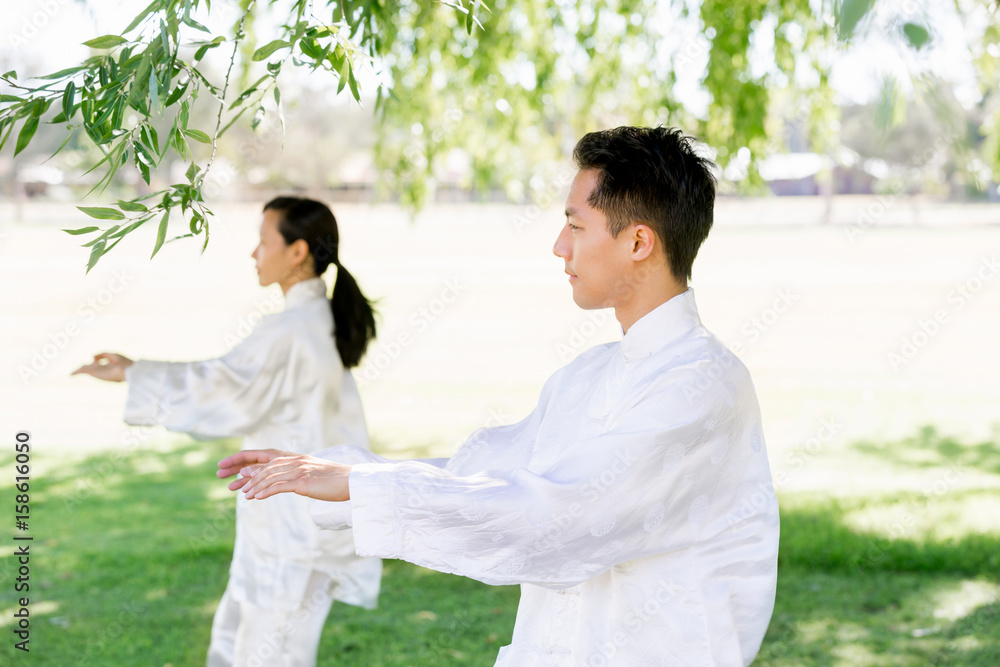 People practicing thai chi in park People practicing thai chi in park