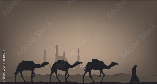 Camels in the desert against the background of the mosque.