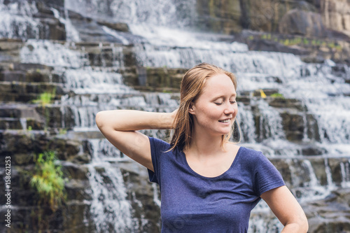 Young woman hiker, tourist on the background of Amazing Pongour Waterfall is famous and most beautiful of fall in Vietnam. Not far from Dalat city estimate 45 Km. Dalat, Vietnam photo