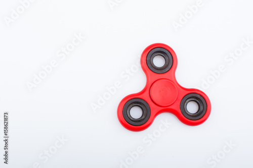 фотографія Red fidget finger spinner stress anxiety relief toy isolated on white background