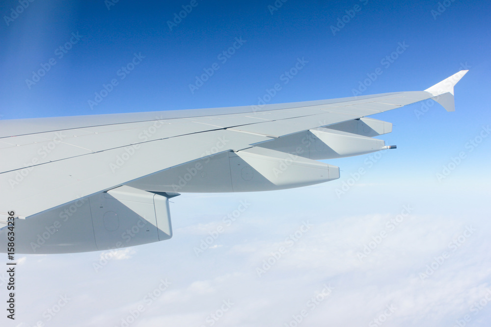 Fototapeta premium Bright blue skies and airplane wing