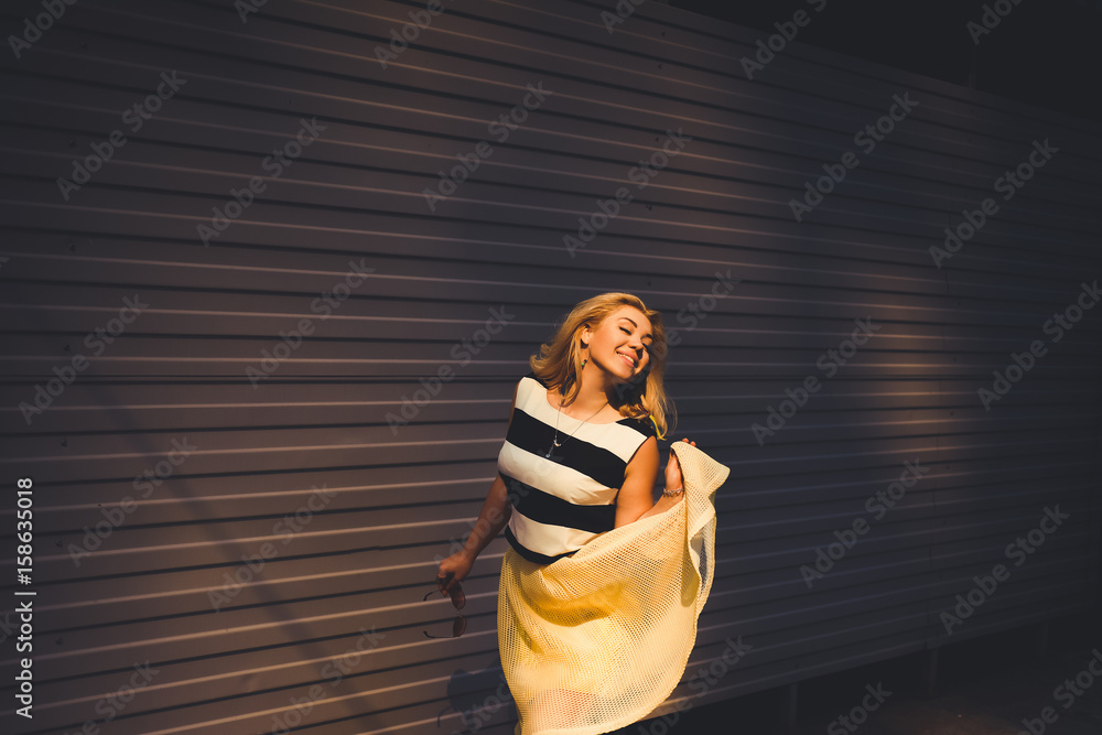 close-up portrait of a beautiful charming girl hipster blonde in a striped blouse and yellow skirt laughing and posing with full lips close-up portrait of a beautiful charming girl hipster blonde in a striped blouse and yellow skirt laughing and posing with full lips