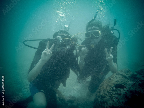 Women scuba divers exploring underwater life in the deep blue ocean